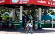 Una persona pasando en bicicleta frente a una estación de gasolina cerrada en La Habana (Cuba).