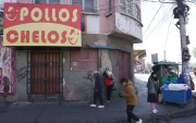 Unas personas pasan al pie de un negocio cerrado por el paro que hay en Bolivia.