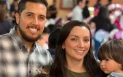 Mathias, de 3 años, junto a sus padres en una reunión con ambiente festivo.