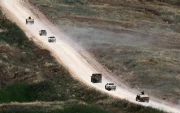 Un convoy de vehículos militares israelíes maniobra dentro del sur del Líbano, visto desde el lado israelí de la frontera en la Alta Galilea.