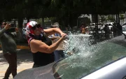 Una persona vandaliza un vehículo este martes, durante una protesta de integrantes de la Coordinadora Nacional de Trabajadores de la Educación (CNTE), en Chilpancingo (México).