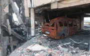 Entre los escombros del centro comercial Multicomercio hay carrocerías de vehículos.