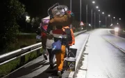 Inmigrantes cargando sus pertenencias caminan por una calle de Stanford, a unos 120 kilómetros de Ciudad del Cabo.