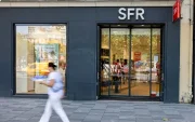 Una persona pasa al pide de una tienda de SFR.