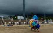 Fotografía referencial, vendedores caminan en una playa.