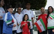 Aficionados iraníes muestran banderas y camisetas durante la llegada de su selección al Aeropuerto Internacional de Tijuana, rumbo al Mundial 2026.