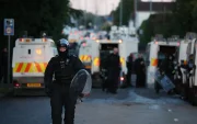 Un agente de policía camina con equipo antidisturbios en el lugar de los disturbios antiinmigración en Antrim Road en Newtownabbey, al norte de Belfast, Irlanda del Norte.
