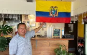 Segundo López posa con orgullo junto a la bandera tricolor que adorna su restaurante, "El Sazón de Doña Eva", en Upper Darby.