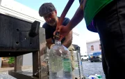 Personas se abastecen de agua tras la interrupción del servicio este lunes, en San Juan (Puerto Rico).