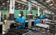 Un grupo de trabajadores cumple con su jornada laboral en una fábrica.