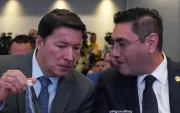 El registrador Hernán Penagos (i) y el presidente del Consejo Nacional Electoral (CNE), Cristian Quiroz, hablan durante la instalación de la Misión de Observación Internacional.