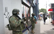Dos militares resguardan una zona de afluencia de civiles en una ciudad.