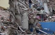 Residentes caminan entre los escombros de edificios derrumbados tras los terremotos en Catia La Mar, estado La Guaira.