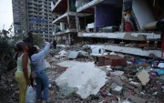 Residentes entre los escombros de uno de los bloques de viviendas dañados por los terremotos, en el estado costero de La Guaira (Venezuela) este jueves.