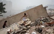 Personas caminan entre los escombros de edificios colapsados tras los terremotos en La Guaira, Venezuela.