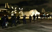 Fotografía cedida por la UNGRD que muestra a integrantes del grupo de búsqueda y rescate USAR COL-1 durante una operación logística nocturna en un avión militar.
