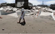 Una habitante de la aldea camina frente a escombros de casas destruidas en Cedeño, al sur de Honduras. El poblado lleva 30 años sufriendo el avance del mar.