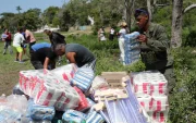 Personas descargan ayudas humanitarias este lunes en La Guaira, Venezuela, tras los sismos.