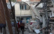 Personas buscan entre los escombros de las edificaciones destruidas por los terremotos.