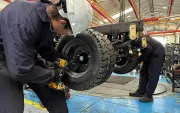 Un par de trabajadores cumplen su jornada laboral en una fábrica de carros.
