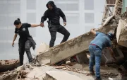 Personas caminan entre los escombros de edificios derrumbados en La Guaira tras los terremotos en Venezuela.