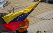 Un integrante de Protección Civil coloca la bandera de Venezuela en La Guaira tras los terremotos