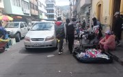 Peatones deben caminar en medio de vehículos, por reubicación de vendedores en la Plaza Primero de Mayo en Ambato.