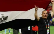 El director técnico de Egipto levanta la bandera nacional durante el partido frente a Argentina.