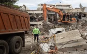 Una persona camina entre máquinas y escombros de edificios colapsados este lunes, en La Guaira (Venezuela).