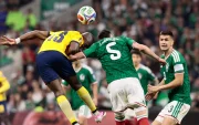 Johan Vásquez (c) de México disputa el balón con Enner Valencia de Ecuador.