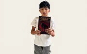 Dilan Chacha, el niño ecuatoriano de 11 años, posa con uno de los libros que escribió.