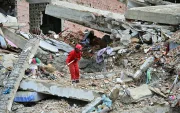 Un trabajador remueve escombros de un edificio colapsado en La Guaira.