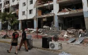 Personas caminan frente a edificios afectados por los terremotos ocurridos en la zona de Caraballeda, en La Guaira (Venezuela).
