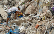 Una persona busca entre los escombros de edificios destruidos por terremotos en Caraballeda.