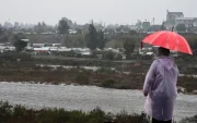Una persona observa el caudal del Río Mapocho al costado de un campamento en riesgo de inundación en la comuna de Talagante (Chile)