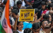 Jóvenes manifestantes en India exhiben carteles creativos durante la protesta que derivó en la renuncia ministerial