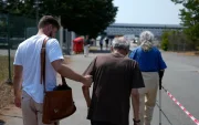 Un joven ayuda a dos personas mayores que se dirigen al Parque de Exposiciones de Burdeos, al suroeste de Francia.