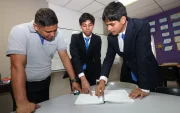 Sebastián Yépez (centro) y Leonel Vargas, del colegio Interamericano, reciben la guía del docente Jhonny Solórzano.