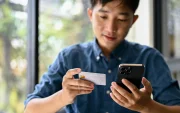 Uso de tarjeta y celular en una transacción digital, reflejo de operaciones que pueden generar errores de transferencia.