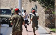 Medios desplegados intentan detener a un migrante este domingo 2 de agosto en Ceuta.