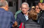 El expresidente (2002-2010), Álvaro Uribe, saluda a un simpatizante a su llegada a un colegio electoral para votar durante la segunda vuelta de las elecciones presidenciales del 21 de junio de 2026.