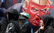Ciudadanos iraníes caminan junto a una pancarta anti-Trump durante la ceremonia del Día de Arbaeen en las calles de la capital, Teherán, Irán, el 4 de agosto de 2026.