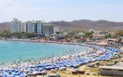 Referencial.Turistas disfrutan de la playa bajo sombrillas en la Costa ecuatoriana, mientras el Inamhi anticipa condiciones variables para el feriado.