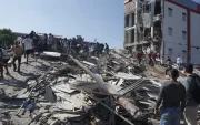 Personas caminan sobre los escombros de un edificio colapsado este lunes, en Cali (Colombia).