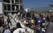 Personas caminan sobre los escombros de un edificio colapsado este lunes, en Cali (Colombia)