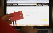 Una persona hace compras en línea usando su tarjeta bancaria.
