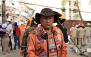 Un rescatista de Topos Azteca explica las posiciones de seguridad durante un terremoto, mientras equipos trabajan entre los escombros.