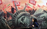Una mujer iraní camina junto a un cartel antiestadounidense en la plaza Enghelab en el centro de Teherán, Irán, el 13 de agosto de 2026.