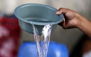 El hondureño Darwin Ordoñez llena un recipiente con agua este 14 de agosto de 2026, en Tegucigalpa (Honduras).