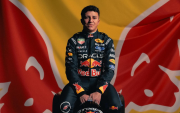 Isack Hadjar posa frente al logo de Red Bull Racing durante su etapa como piloto de la escudería.